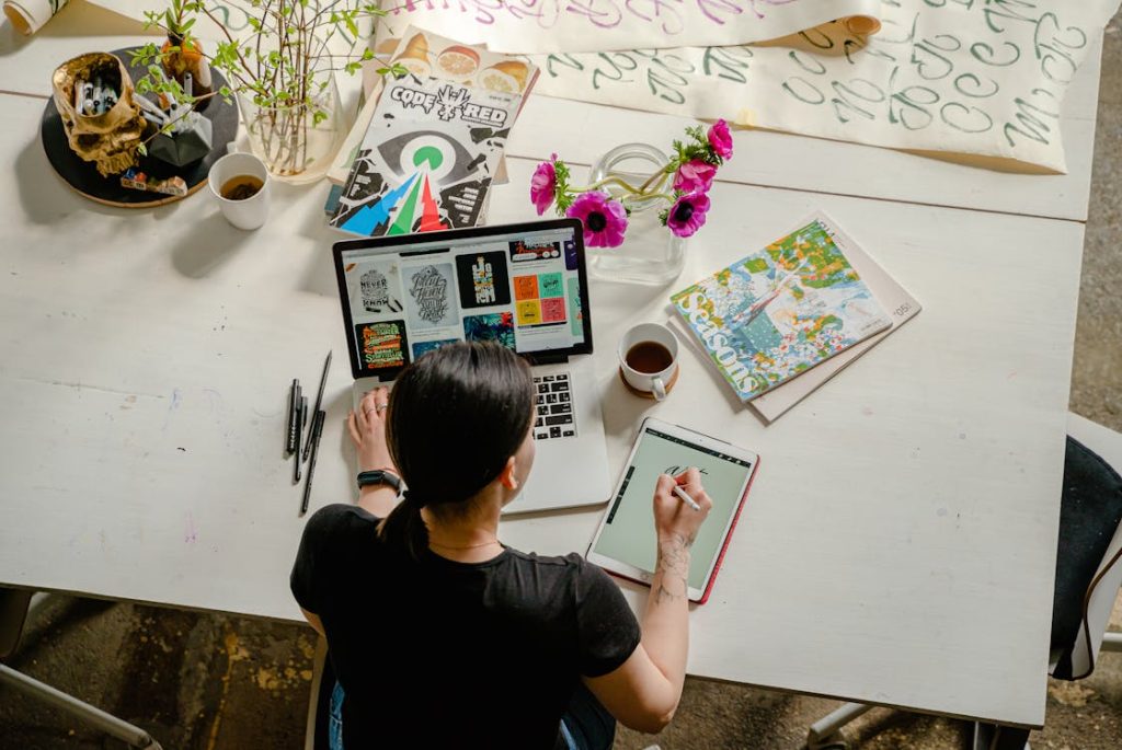 Free Photo of Woman Writing on Tablet Computer While Using Laptop Stock Photo